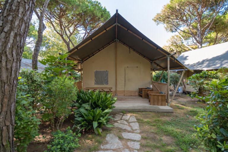 Esterno del Natura Lodge immersa tra alberi e vegetazione nel camping Cavallino