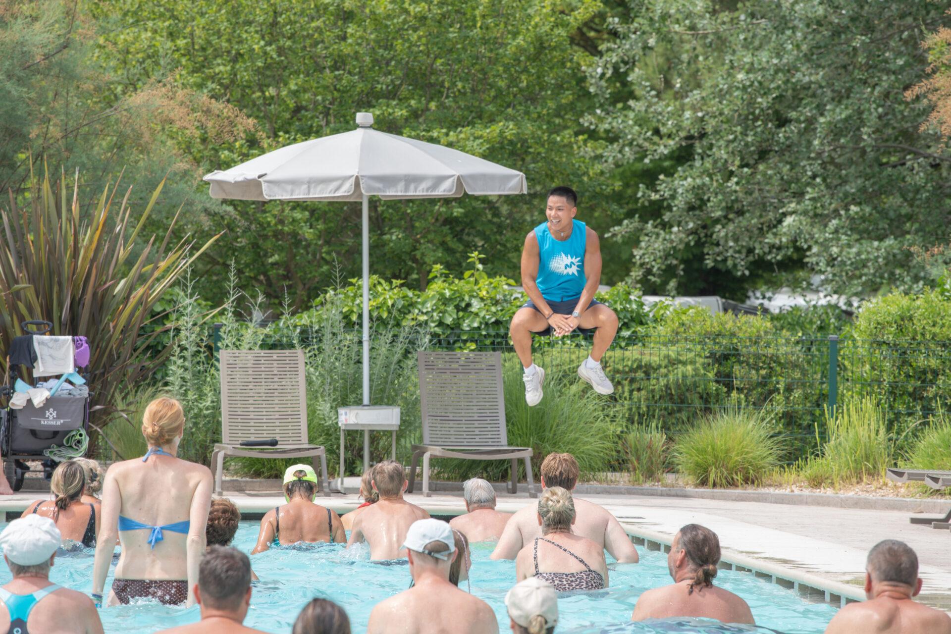 Istruttore mostra un esercizio con salto a un gruppo di ospiti durante una lezione di aquagym al Camping Mediterraneo