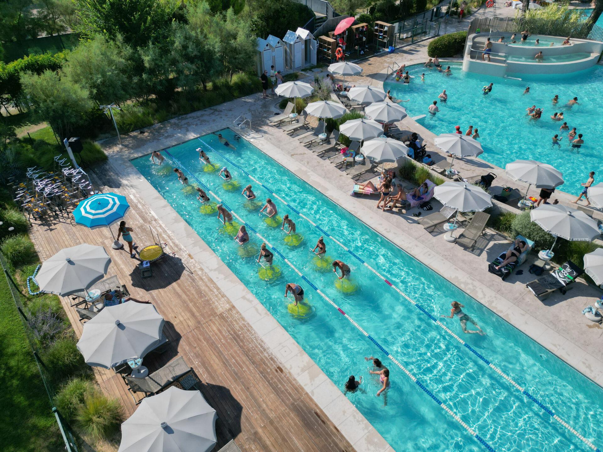 Vista aerea di una lezione di aquajump con ospiti sui trampolini acquatici nella piscina del Camping Mediterraneo