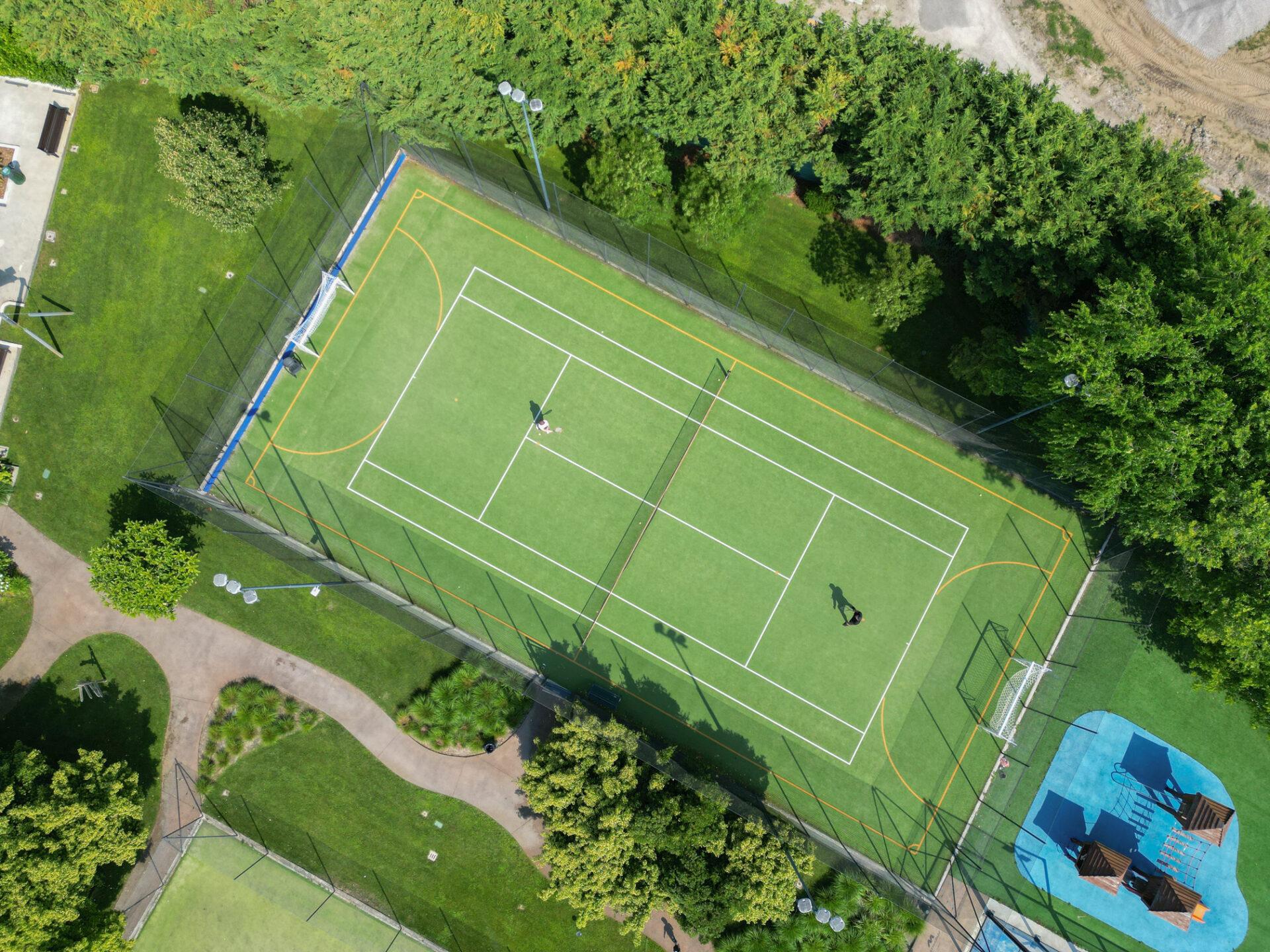 Vista aerea del campo polivalente da calcio e tennis del Camping Mediterraneo con due giocatori e porte da calcio
