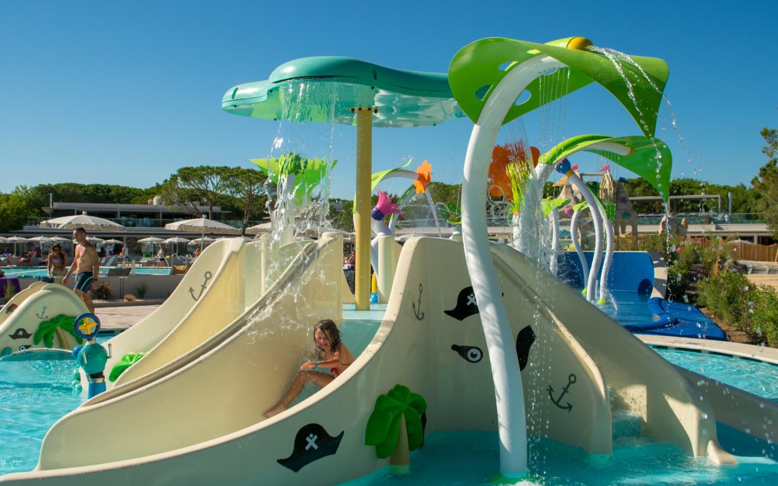 Bambina sullo scivolo della Baby Pool con giochi d’acqua colorati